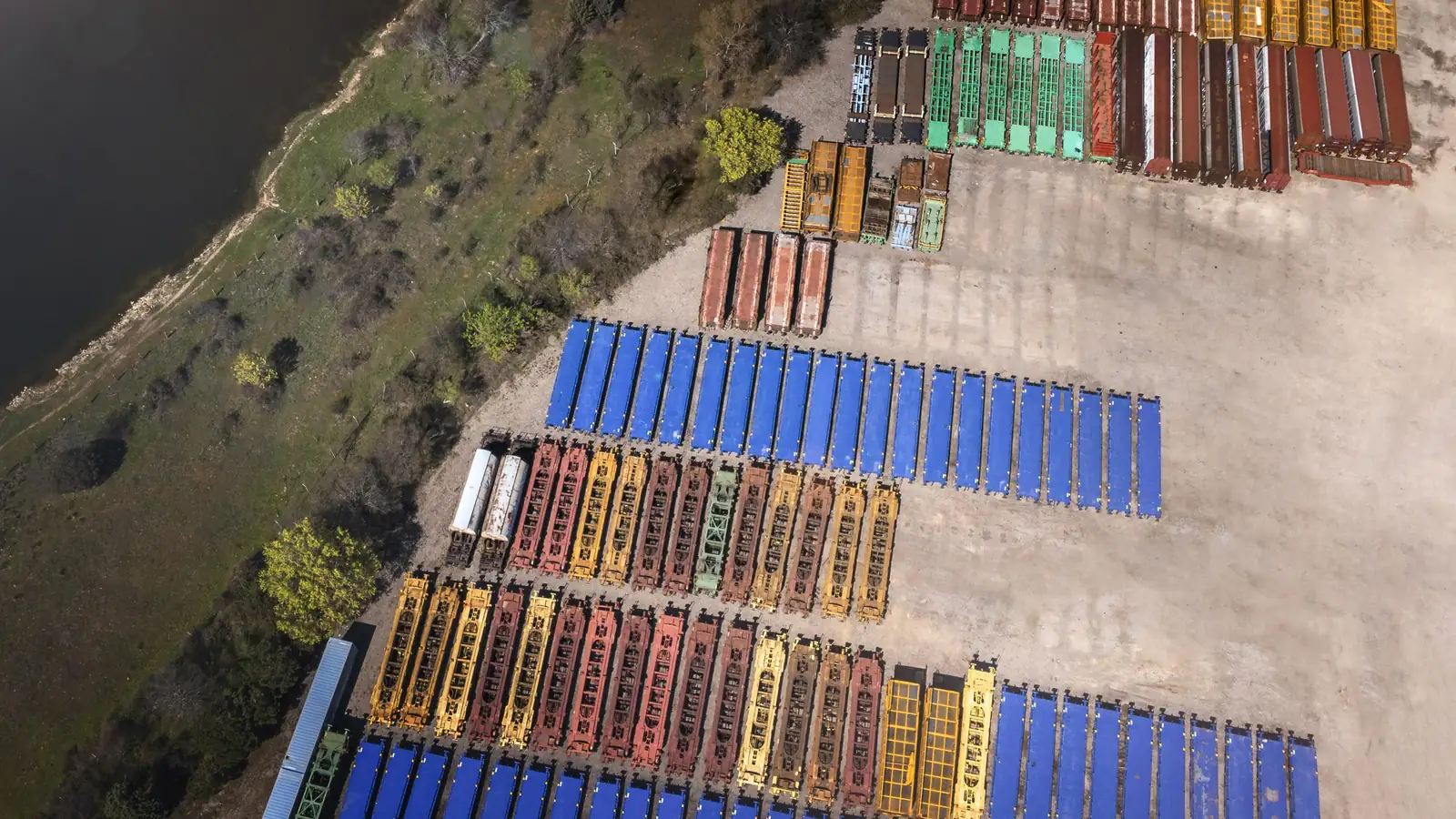 Aerial view of rows of colorful shipping containers at a port.