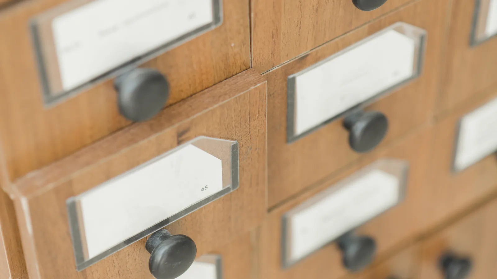 Wooden card-catalogue drawers with blank label holders.